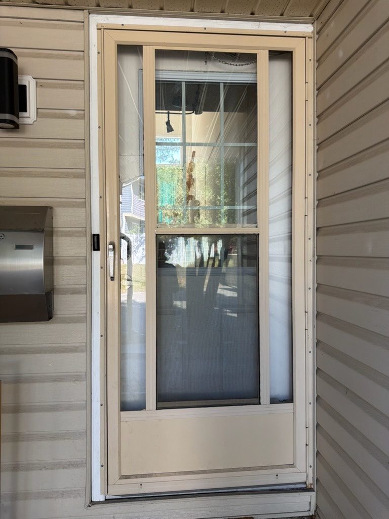 Old almond storm door before replacement in Calgary