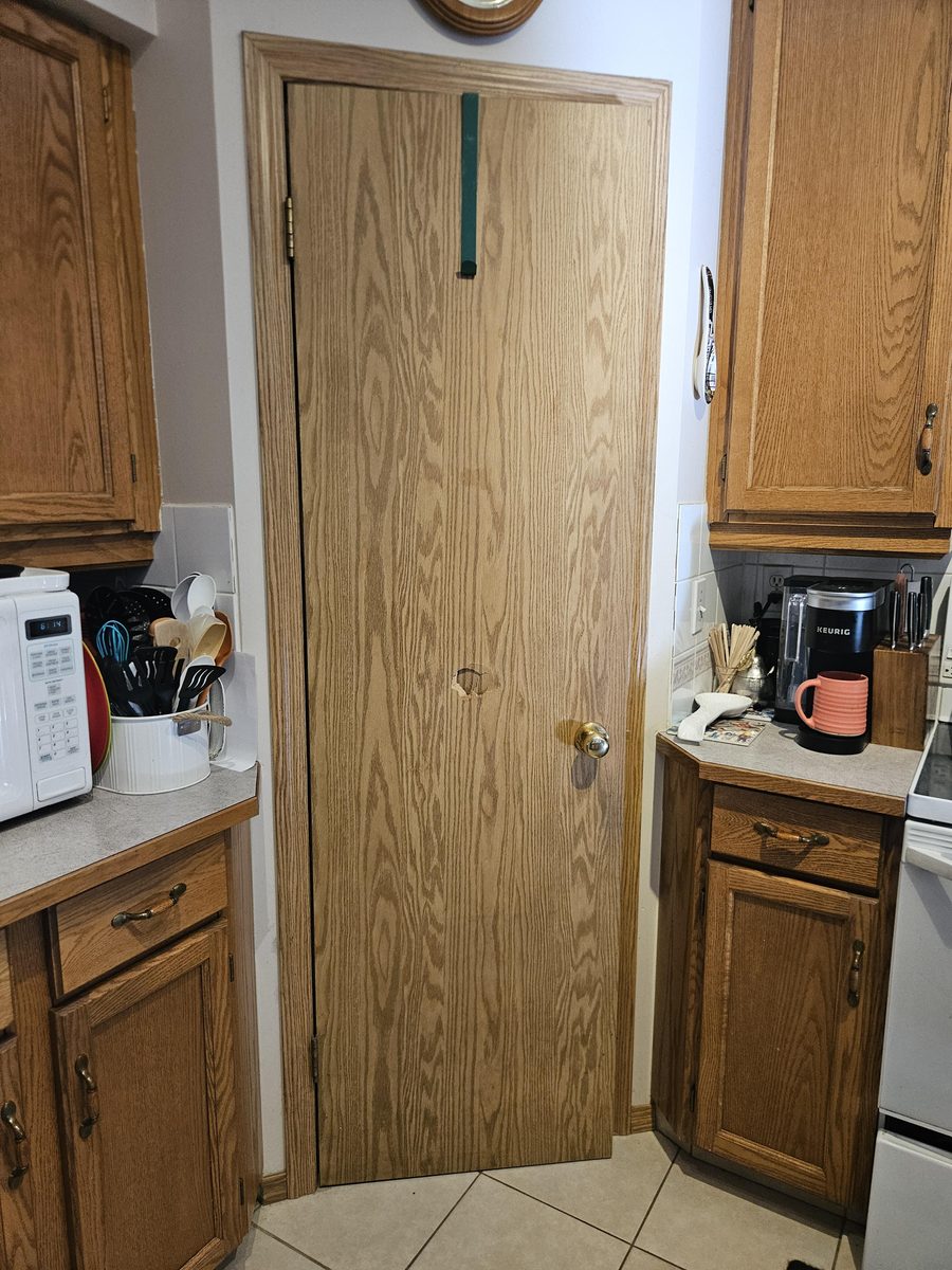 Damaged pantry door with hole before replacement in Harvest Glen, Calgary