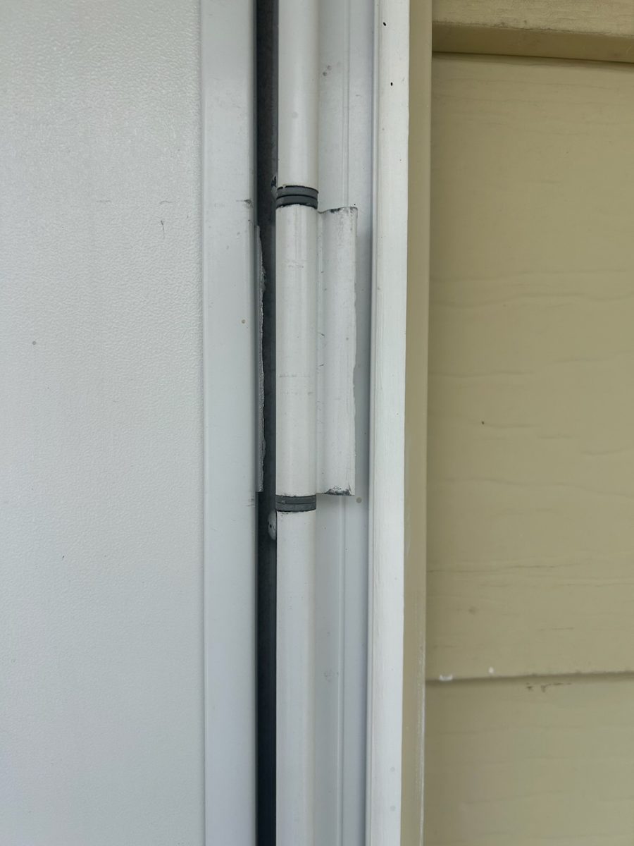 Storm door hinge torn out by wind in Pineridge, Calgary